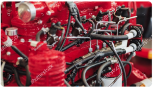 Close-up of a powerful red combustion engine showing complex network of pipes and wires
