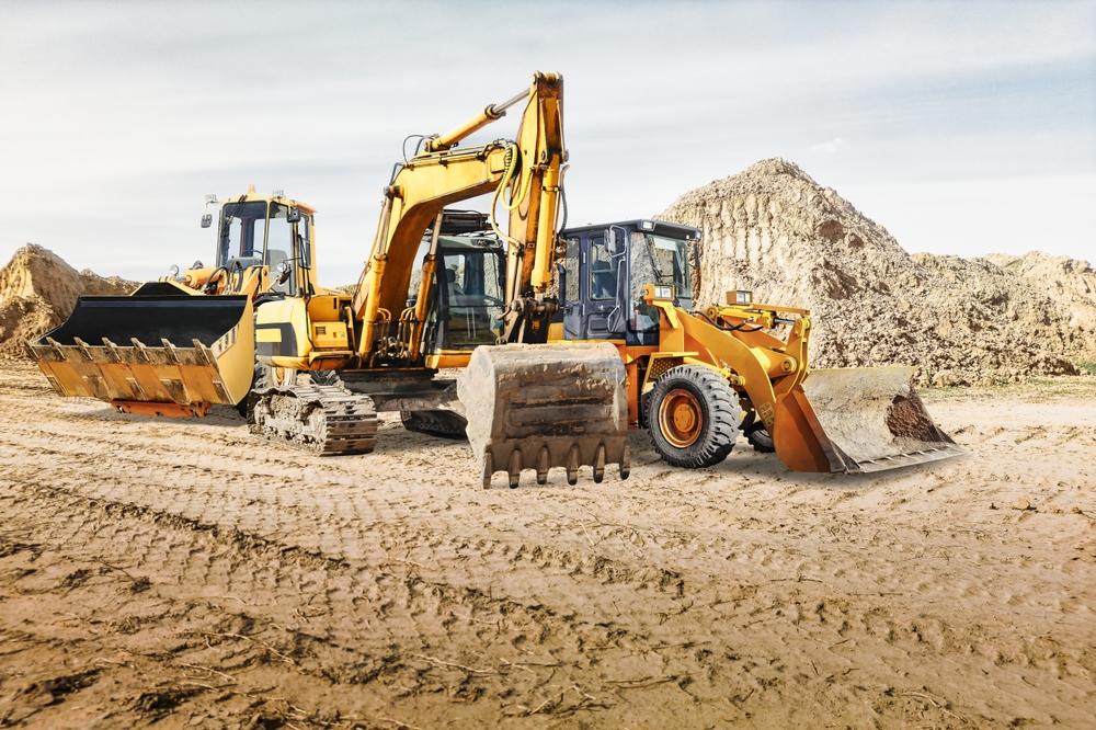 Construction Equipment moving dirt around a construction site.